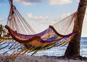 Hammock swinging from two palm trees on a beach in Belize