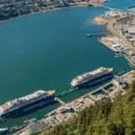 Downtown Juneau and cruise ship port with two ships docked, aerial view from Mount Roberts cable tram. Juneau, Alaska, USA.